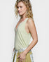 Woman wearing a light green sleeveless top with a white background