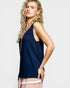 Woman wearing a navy blue sleeveless top with a colorful trim on a white background