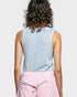 Person wearing a light blue sleeveless top and pink pants on a plain background