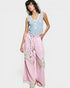 Woman wearing a light blue sleeveless top and pink pants with star patterns on a white background