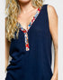 Navy blue sleeveless top with colorful patterned neckline on a plain background