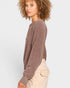 Woman wearing a brown sweater and beige pants on a white background