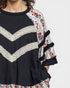 Navy blue top with white lace details and floral embroidery on a plain background