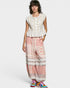 Woman wearing a white lace top and pink lace pants on a white background