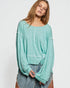 Woman wearing a light blue ribbed sweater on a white background