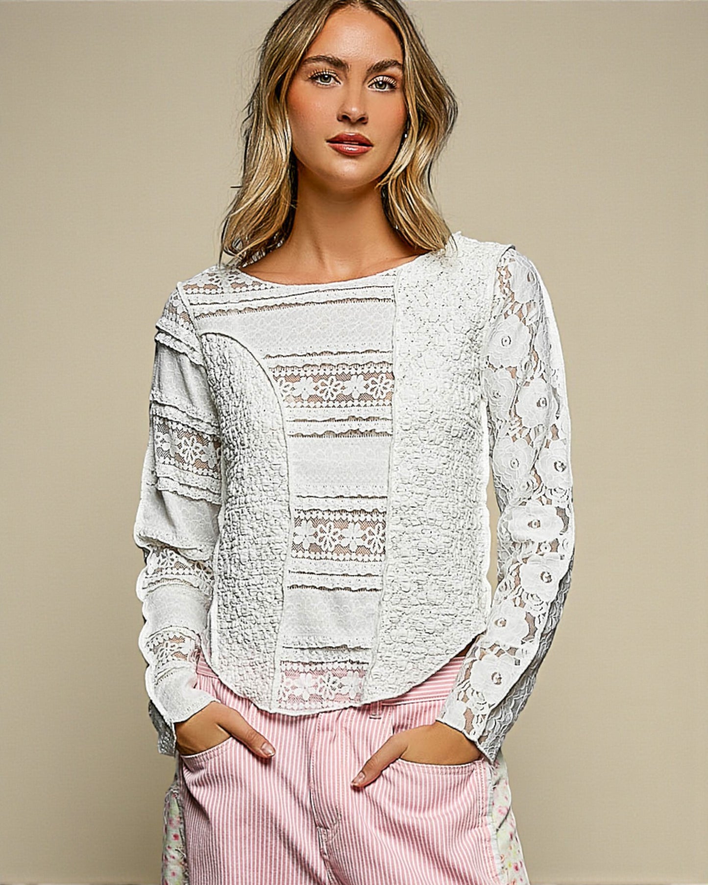 Woman wearing a white lace top with a beige background