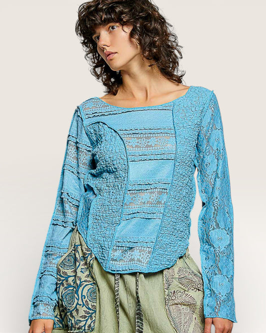 Woman wearing a blue textured top with a neutral background