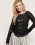 Woman wearing a black lace top with a plain background