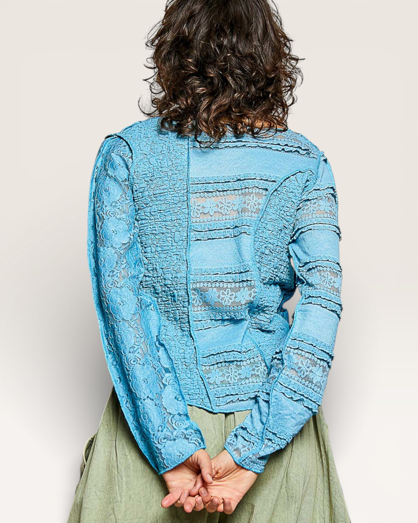 Person wearing a blue textured jacket with a neutral background