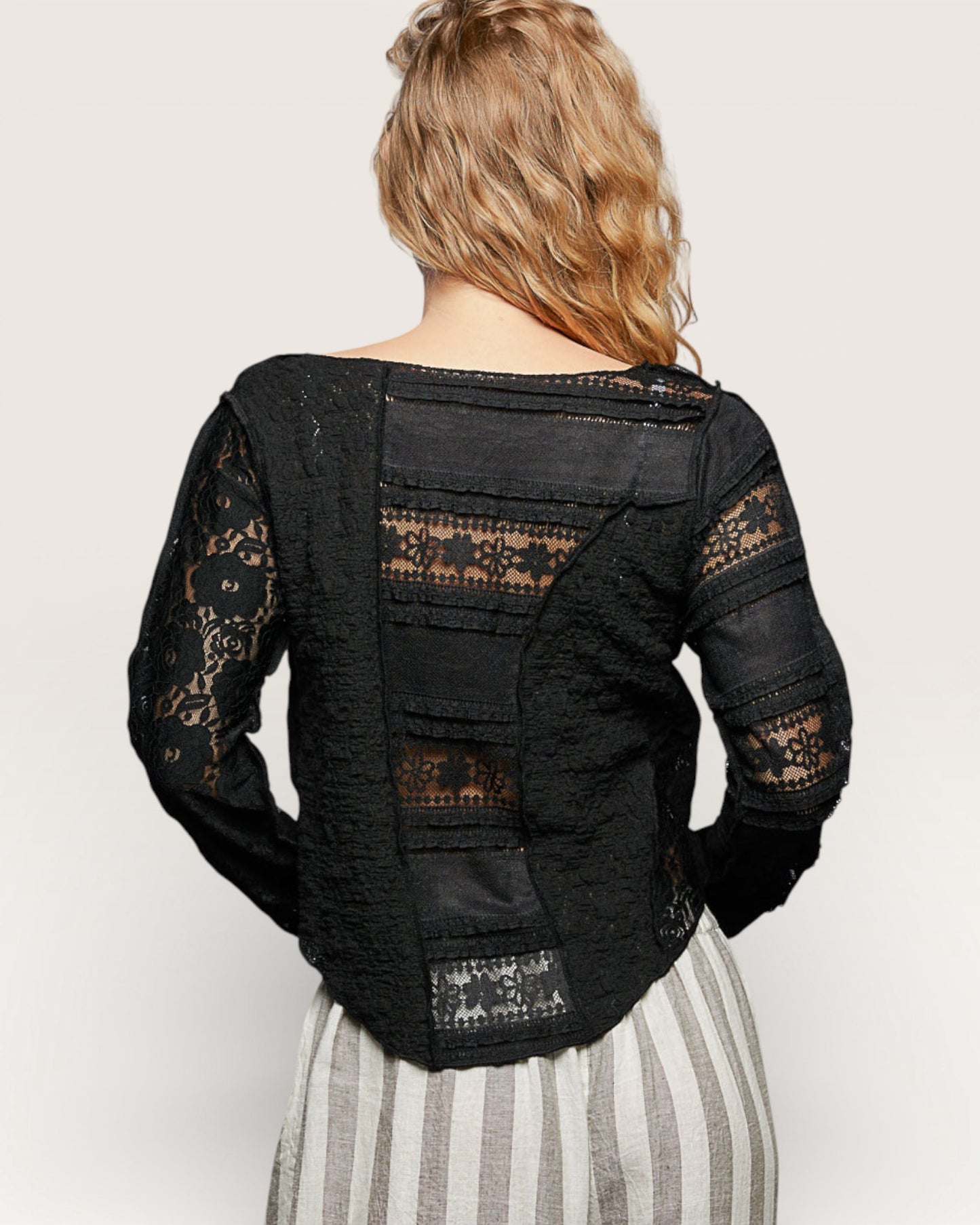 Black lace jacket worn by a person on a plain background