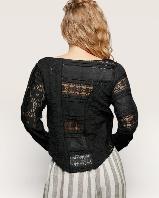 Black lace jacket worn by a person on a plain background