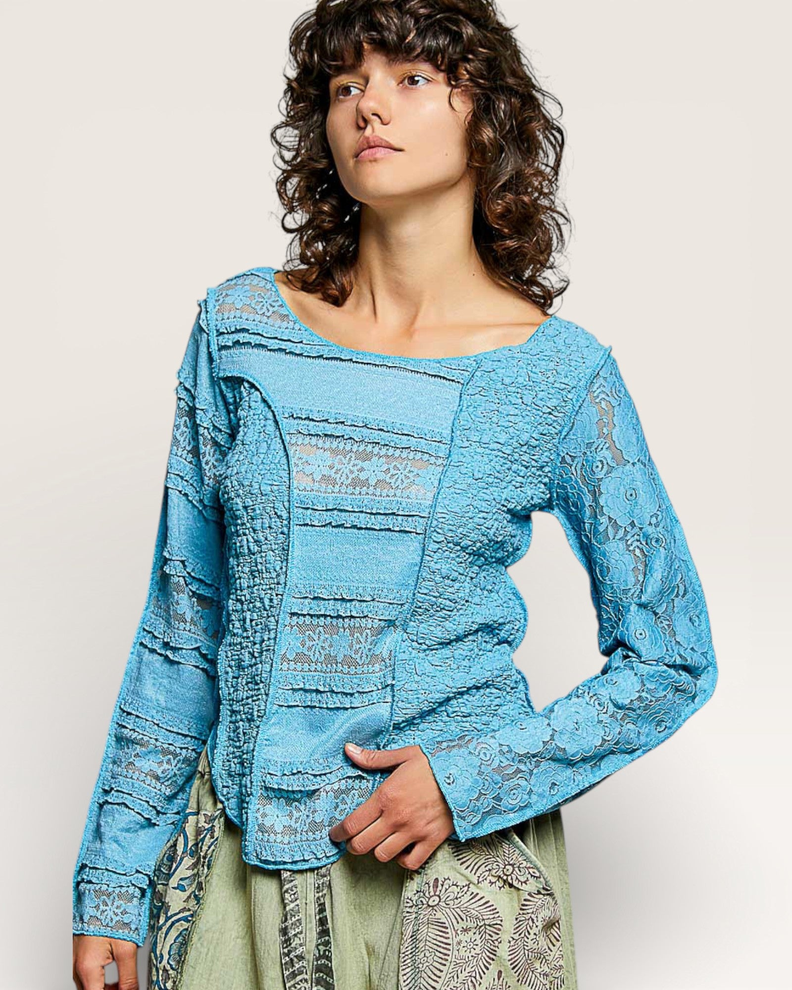 Woman wearing a blue textured top with a plain background