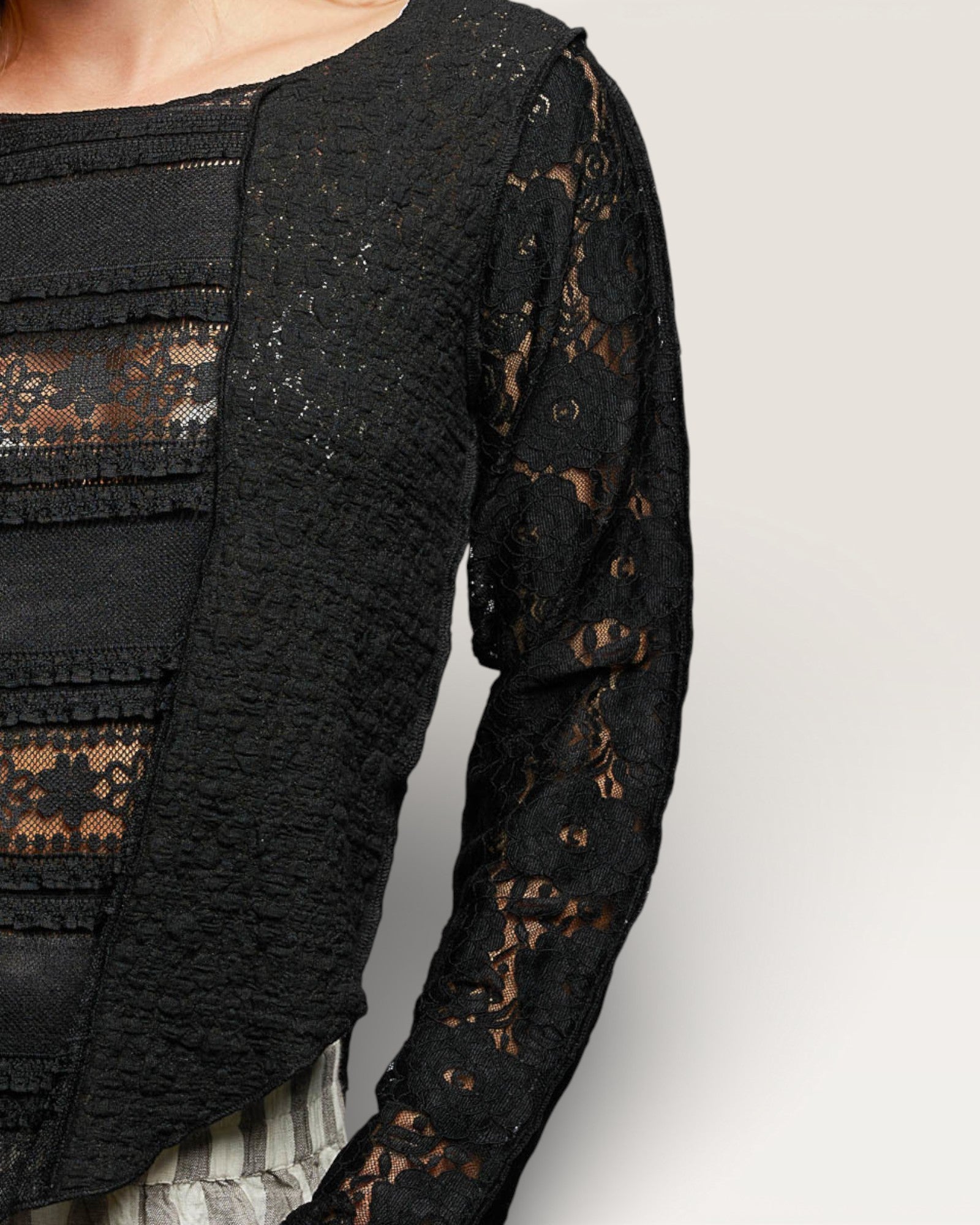 Black lace top with long sleeves on a neutral background