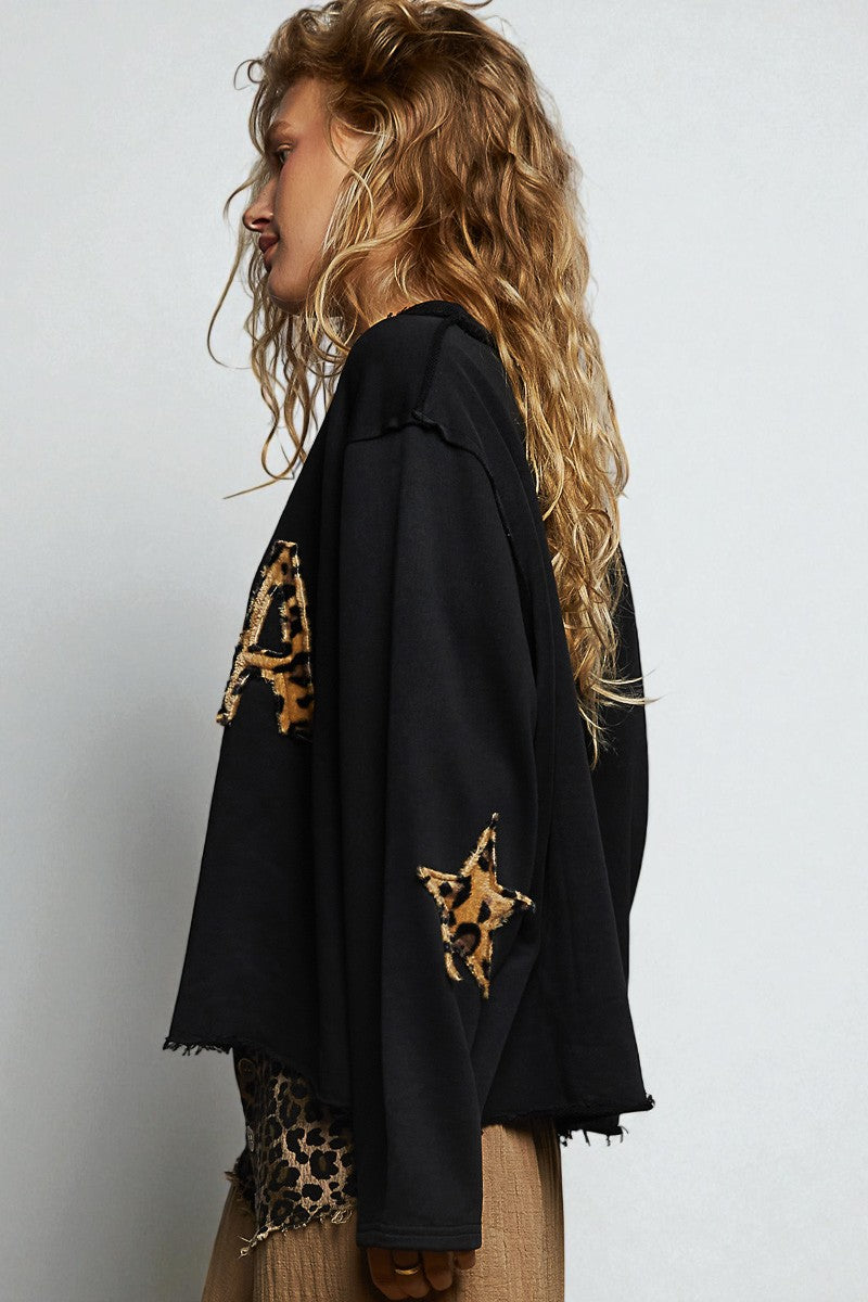 Woman wearing a black outfit with leopard print accents on a white background