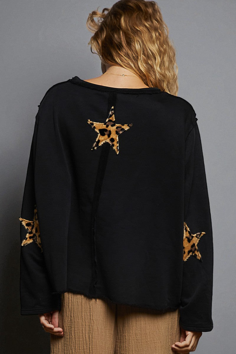 Black top with leopard print star designs on a gray background