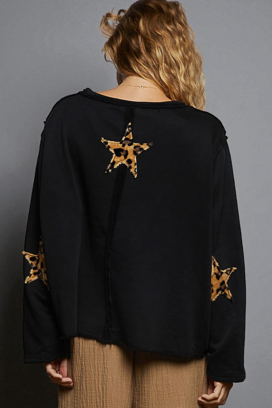 Black top with leopard print star designs on a gray background