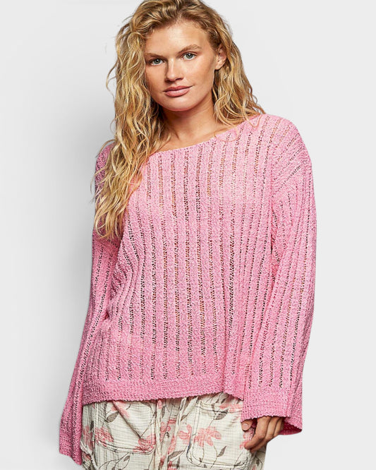 Woman wearing a pink knitted sweater on a white background