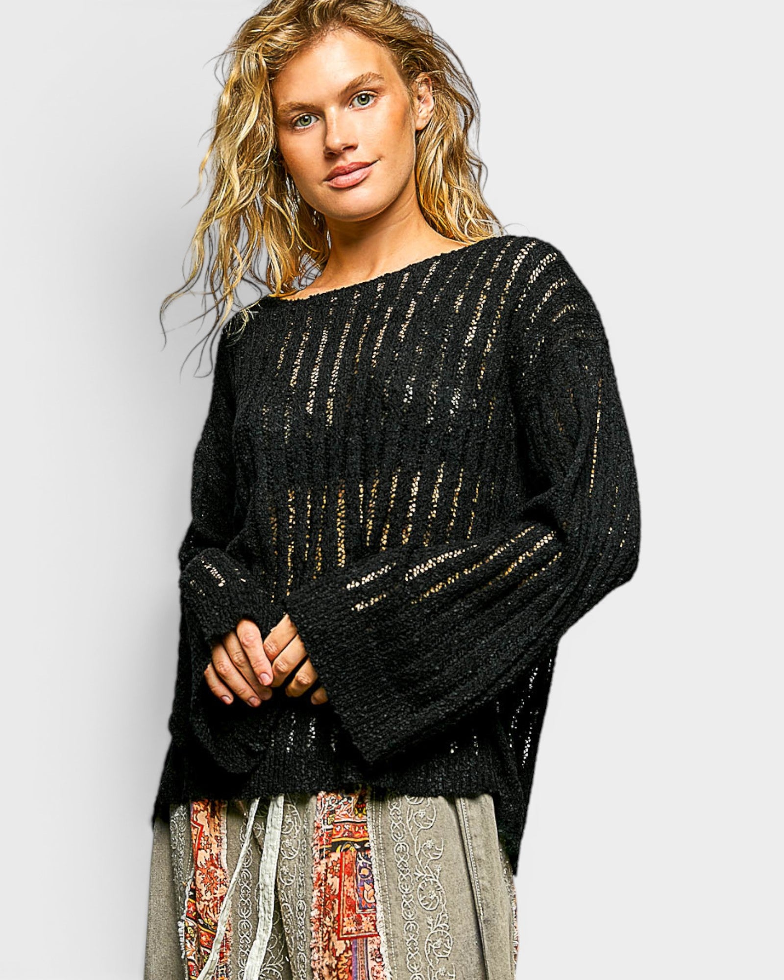 Woman wearing a black textured sweater with a plain background