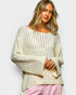 Woman wearing a cream-colored sweater with a plain background