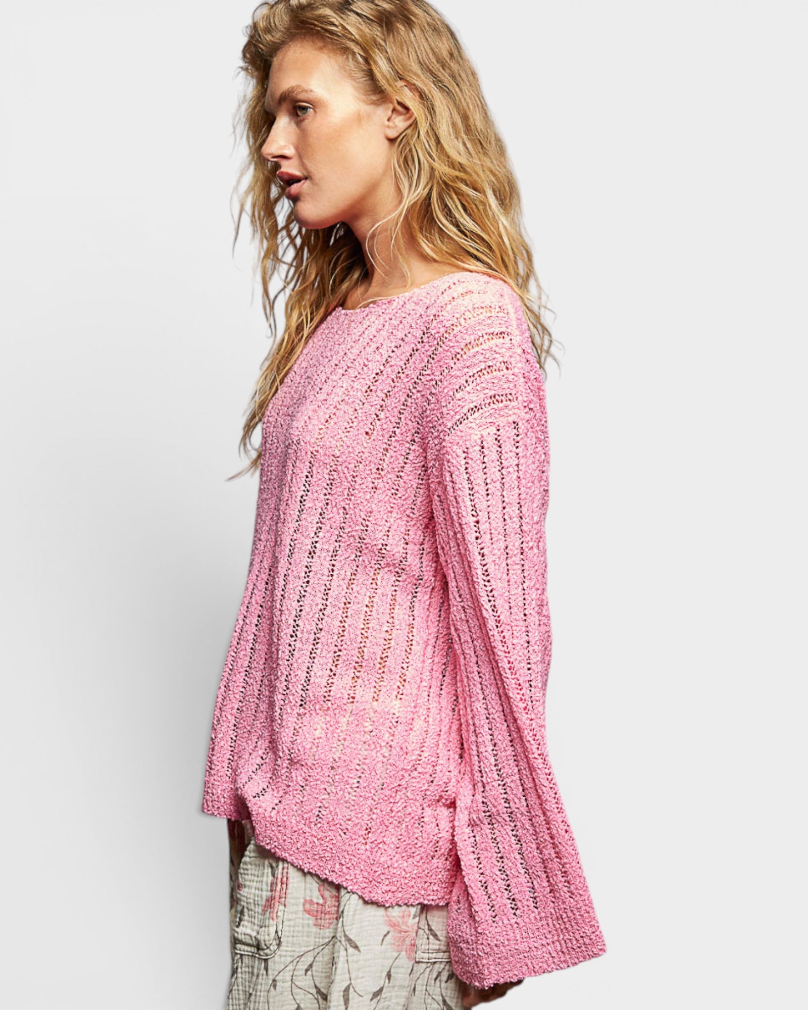 Woman wearing a pink knitted sweater on a white background