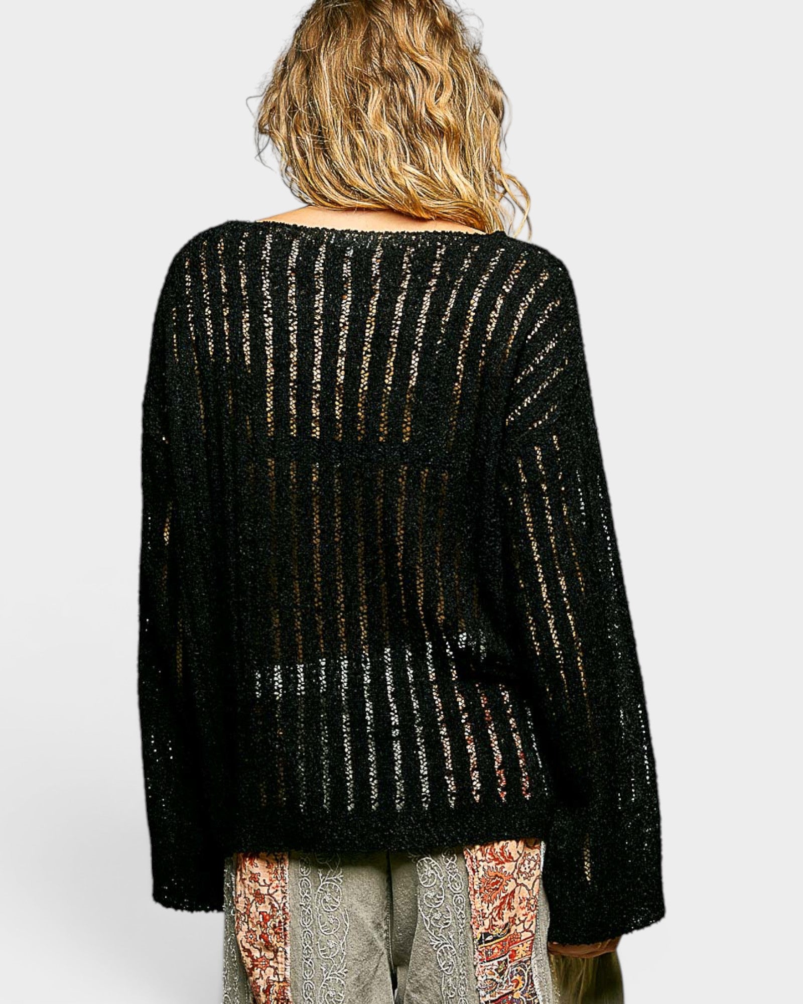 Black textured sweater worn by a person on a white background