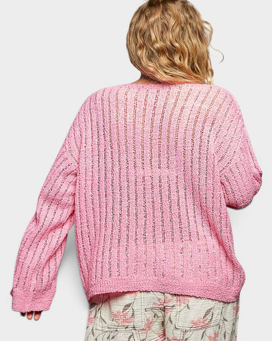 Pink knitted cardigan on a person against a white background