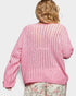 Pink knitted cardigan on a person against a white background