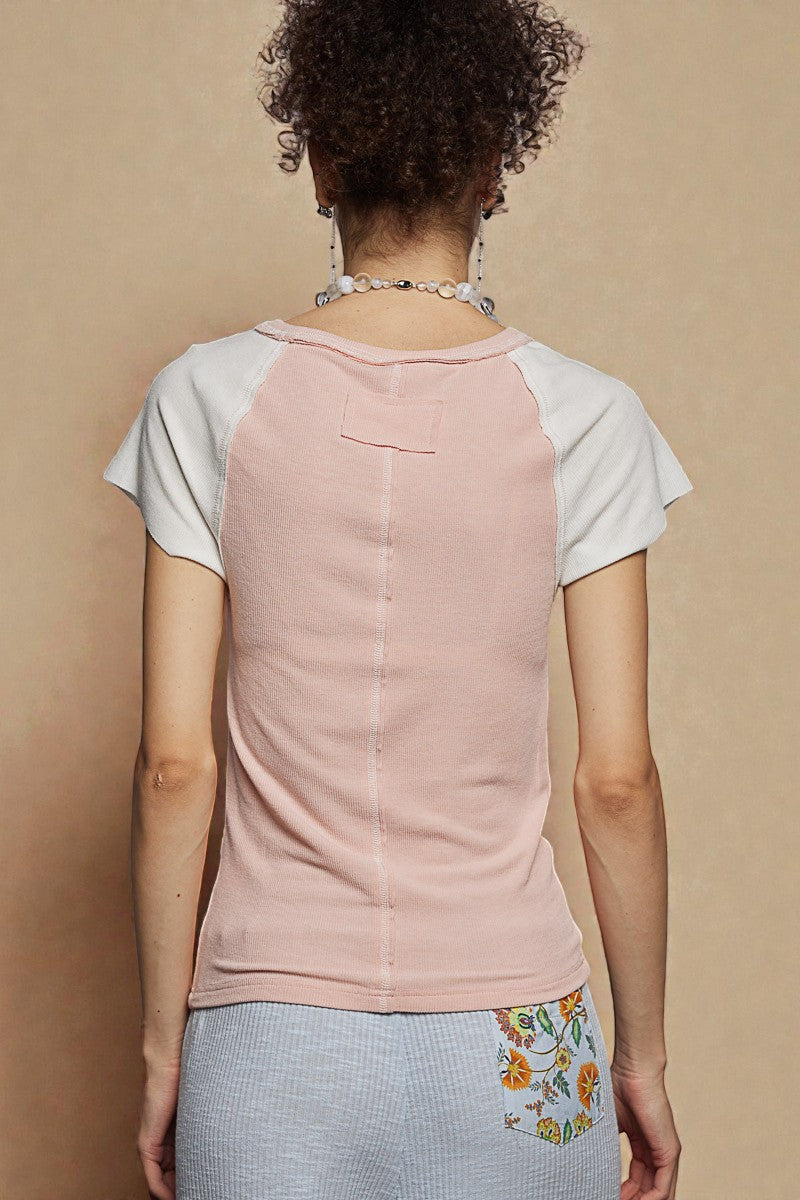 Person wearing a two-tone t-shirt with a beige background