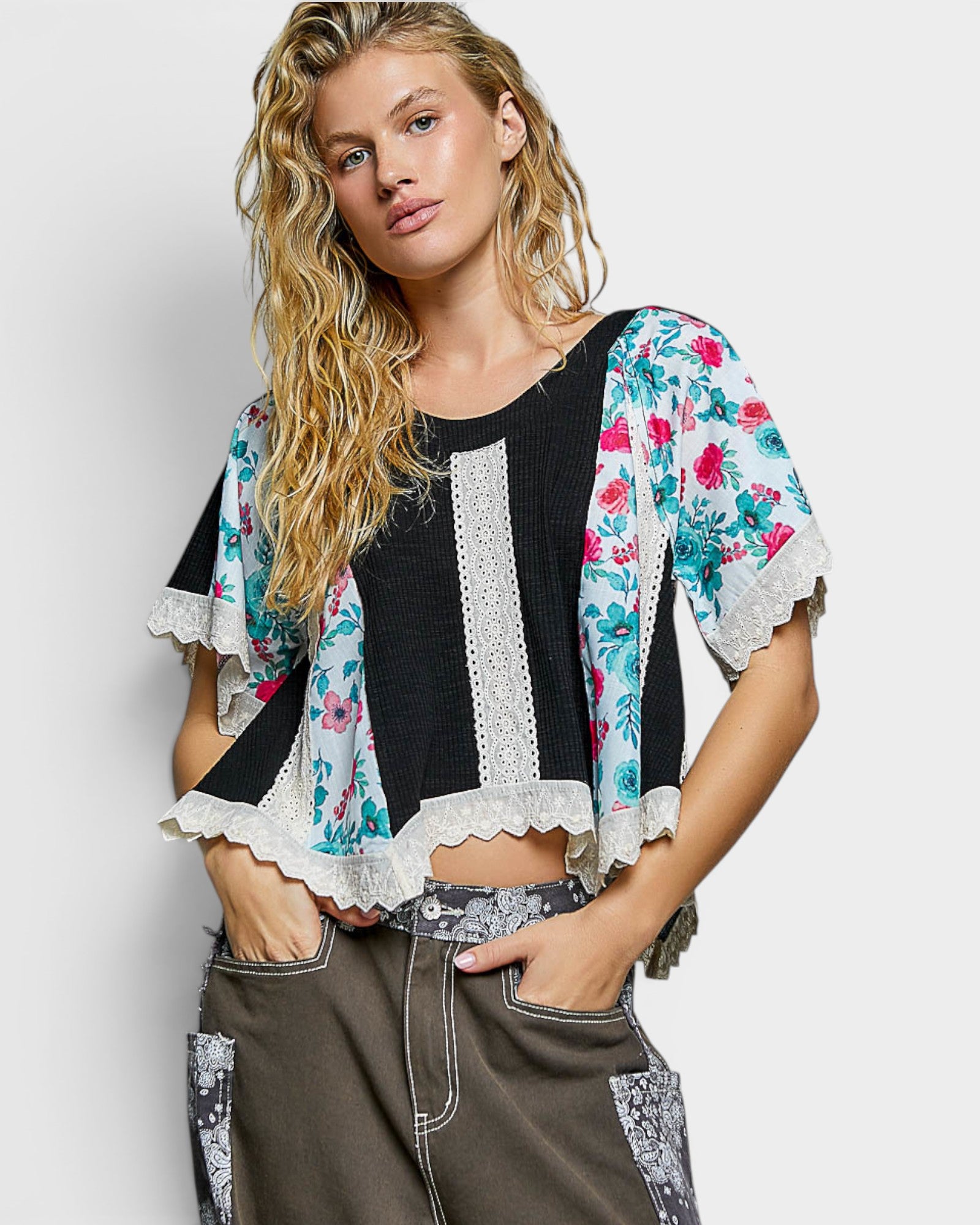 Woman wearing a floral kimono-style blouse with a white background