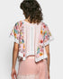 Woman wearing a floral kimono-style jacket over a pink outfit on a white background