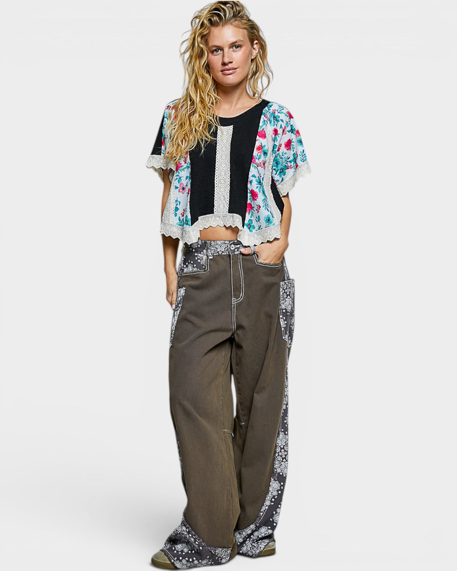 Woman wearing a floral kimono-style top and wide-leg pants on a white background