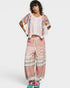 Woman wearing a floral kimono and pink lace pants on a white background