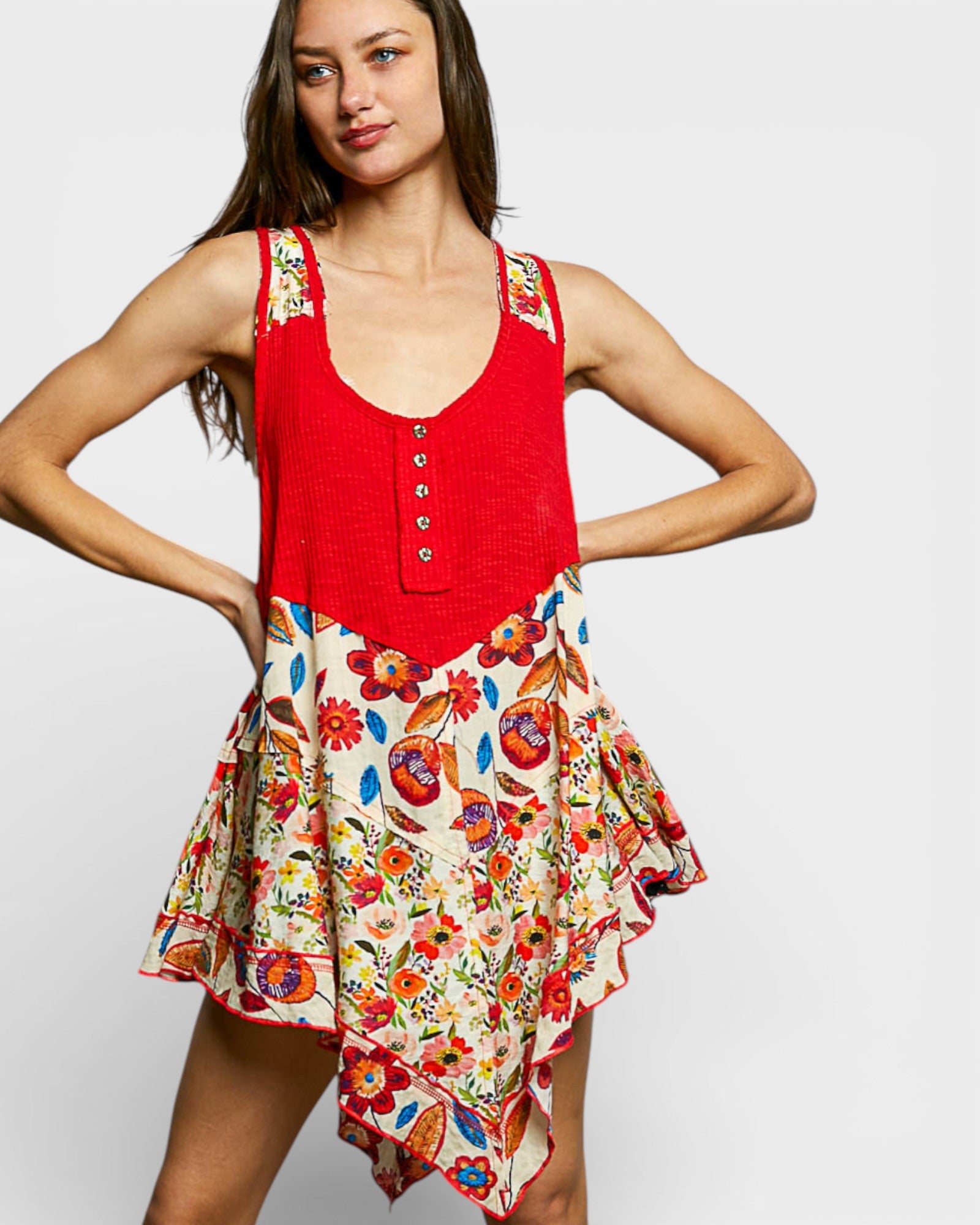 Woman wearing a red top with floral patterns on a plain background