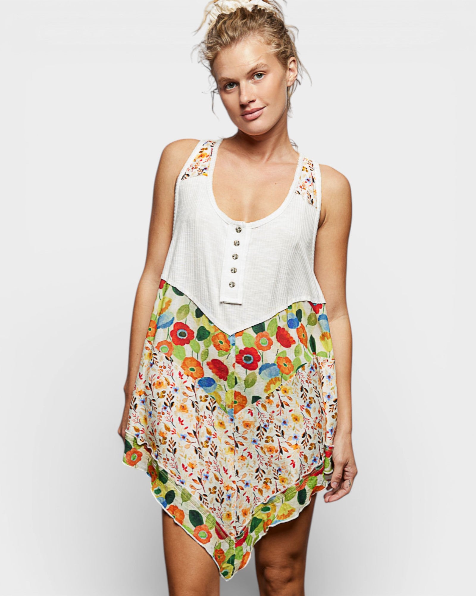 Woman wearing a white top with floral skirt on a plain background