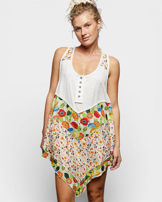 Woman wearing a white top with floral skirt on a plain background