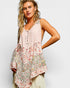 Woman wearing a sleeveless floral top with a plain background