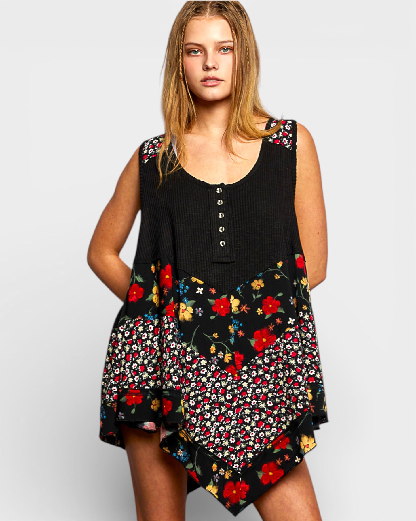 Woman wearing a black sleeveless top with floral skirt on a white background