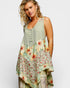 Woman wearing a sleeveless, floral-patterned dress on a white background