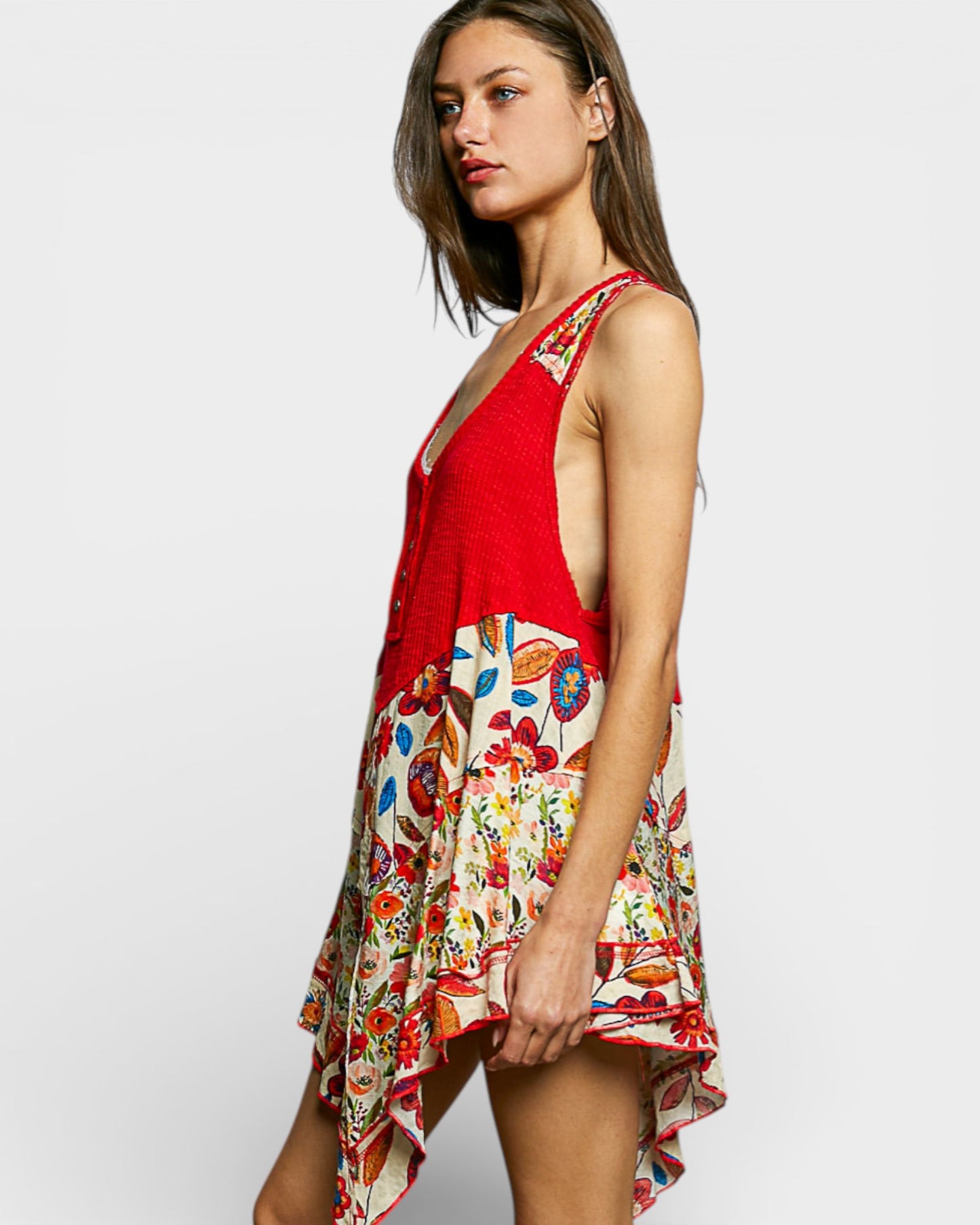 Woman wearing a red top with a colorful floral skirt on a white background