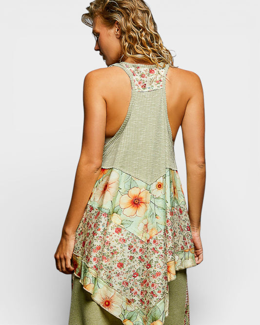 Woman wearing a sleeveless top with floral patterns on a plain background