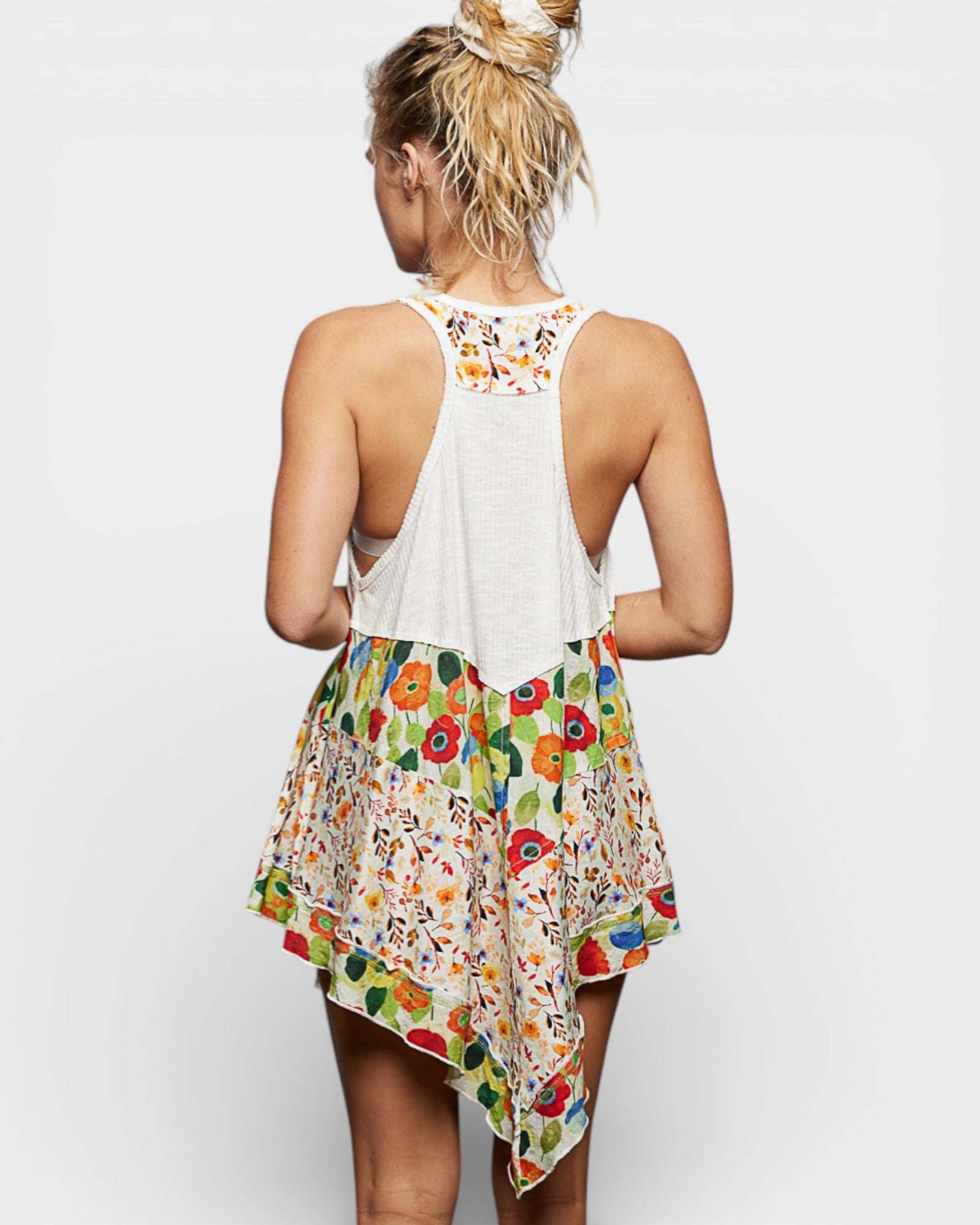 Woman wearing a colorful floral dress with a plain background