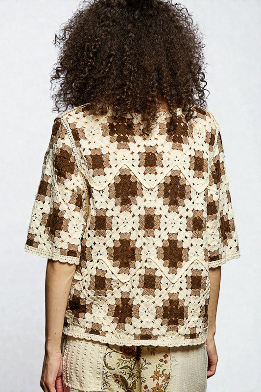 Person wearing a brown and white checkered shirt with a plain background