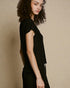 Woman wearing a black outfit against a beige background