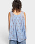 Woman wearing a light blue floral sleeveless top against a white background
