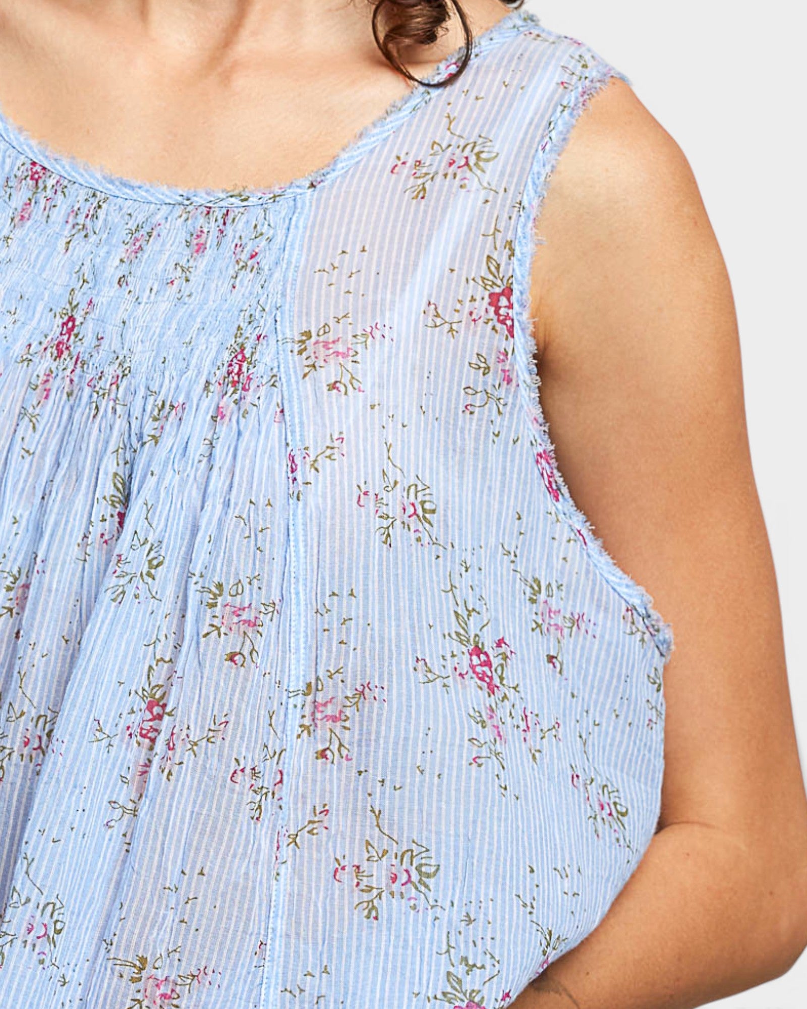 Light blue sleeveless top with floral pattern on a plain background