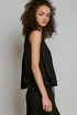 Woman wearing a black sleeveless top against a plain background