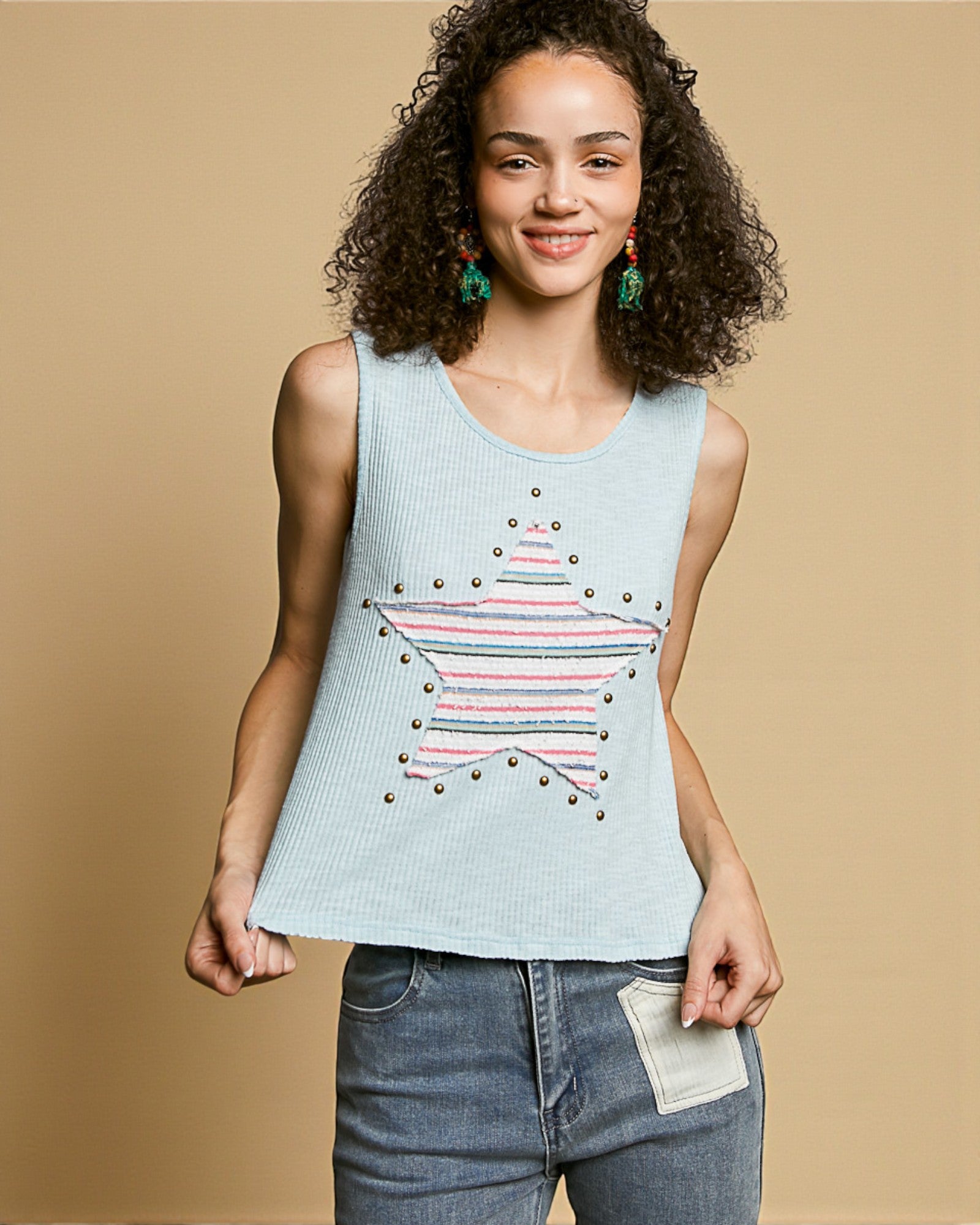 Woman wearing a light blue tank top with a star design on a beige background