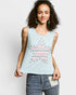 Woman wearing a light blue sleeveless top with star design and jeans on a plain background