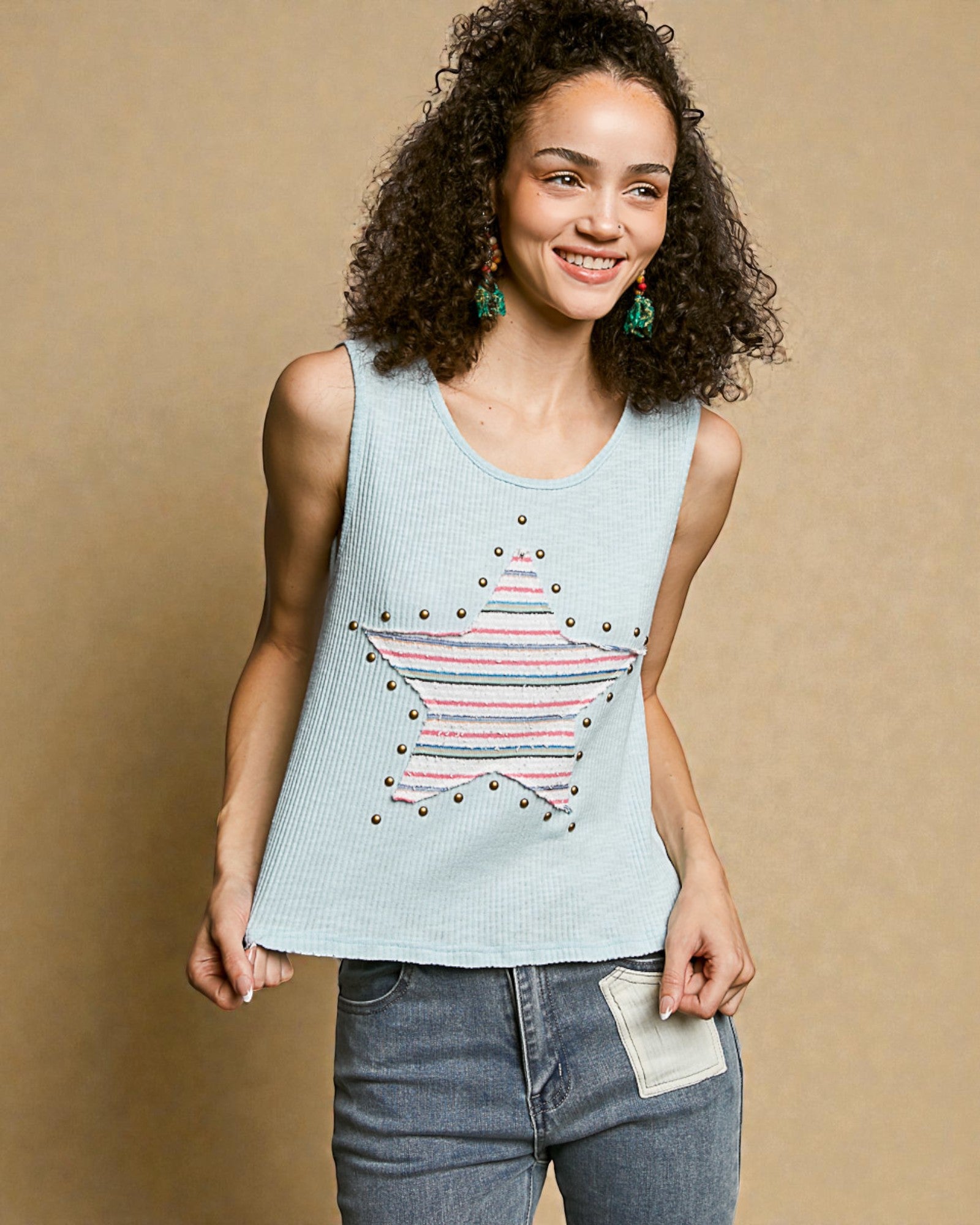 Woman wearing a light blue tank top with a star design on a beige background