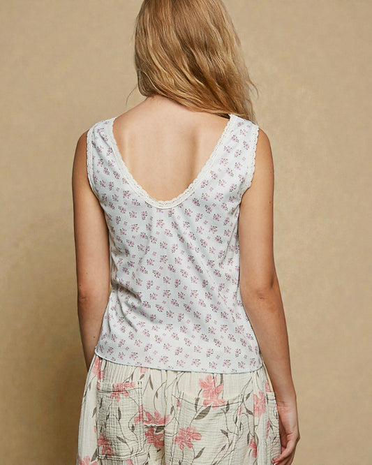 Woman wearing a floral sleeveless top and skirt on a beige background